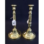 Pair of continental loaded brass candlesticks of gun barrel form with armorial devices, probably
