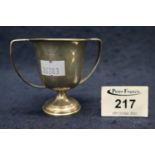 Small silver two handled trophy cup of plain design on pedestal base. Birmingham hallmarks, makers