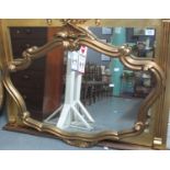 Modern gilt framed mirror of oval form with scroll decoration. (B.P. 21% + VAT)