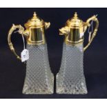 Pair of glass moulded conical claret jugs with gilt metal mounts, covers and foliate loop handles.