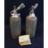 Two similar vintage soda syphons with metal wicker finish mounts and a box of Sparklets bulbs. (B.P.