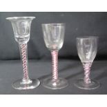 GROUP OF THREE MULTIPLE RED AND WHITE AIR TWIST DRINKING GLASSES of different shapes and sizes.