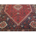 20TH CENTURY RED AND BLUE GROUND MIDDLE EASTERN CARPET overall decorated with animals and