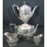A TWO PIECE LATE VICTORIAN PART TEA SERVICE of fluted classical form with ebonised handles and