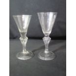 TWO 18TH CENTURY CONICAL WINE GLASSES with tapering stems and folded feet, light probably soda