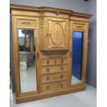 LATE VICTORIAN OAK BREAK FRONT WARDROBE having moulded and dentil cornice with moulded cherub face