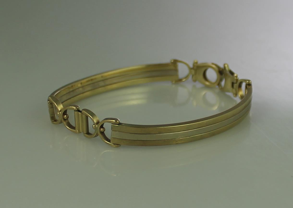 9CT WHITE AND YELLOW GOLD BRACELET of two curved bars with horseshoe links. Weight 13.2g approx. (