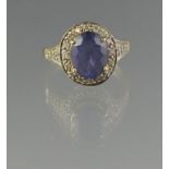 18CT GOLD OVAL TANZANITE AND DIAMOND RING. Diamond 9 x 7mm approx. Ring size N & 1/2. Weight 3.8g
