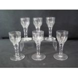 A SET OF SIX 19TH CENTURY WINE GLASSES with thumb cut bowls and facet cut stems on circular bases