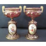PAIR OF 19TH CENTURY BOHEMIAN RUBY GLASS PEDESTAL URN SHAPED TWO HANDLED VASES, of baluster form