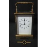LATE 19TH/EARLY 20TH CENTURY GILT BRASS TWO TRAIN CARRIAGE CLOCK with swing handle to the gorge case