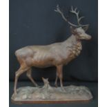 EARLY 20TH CENTURY CARVED BLACK FOREST STAG with five point metal antlers, standing on a carved