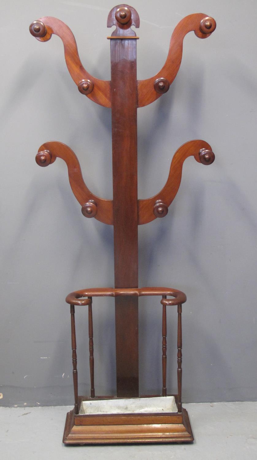 A VICTORIAN MAHOGANY TREE SHAPED UMBRELLA AND HAT STAND of scrolled form with open umbrella stand on