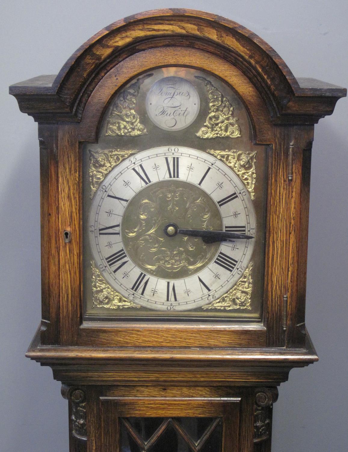 20TH CENTURY STAINED OAK LONGCASE CLOCK having arched hood above brass face with silvered Roman