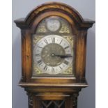 20TH CENTURY STAINED OAK LONGCASE CLOCK having arched hood above brass face with silvered Roman
