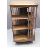EDWARDIAN MAHOGANY REVOLVING BOOKCASE having moulded top of square form above three shelves,