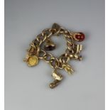 9CT GOLD HOLLOW LINK CURB CHARM BRACELET with various charms including; teddy bear, boot, amethyst