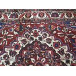 PERSIAN BAKHTIARI WOOL CARPET overall decorated on a red ground with stylised floral and foliate