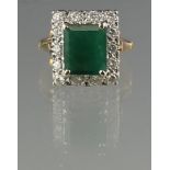 LARGE EMERALD AND DIAMOND RING. The step cut emerald approx 10 x 9mm, surrounded by 14 diamonds.