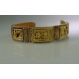 18CT GOLD WIDE HEAVY BRACELET of rectangular links with engraved scenes. Having clasp and safety