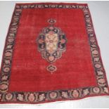 PERSIAN RED GROUND RUG with foliate central medallion and blue ground border. 185 x 115cm approx. (