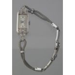 ART DECO DESIGN PLATINUM DIAMOND SET LADIES COCKTAIL WATCH with rectangular Arabic face on a white