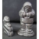 TWO INUIT CARVED HARDSTONE FIGURES to include; a fisherman with his catch on his back walking on