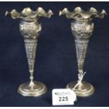 Pair of Indian silver trumpet shaped vases with waved flared necks, repousse decoration and circular