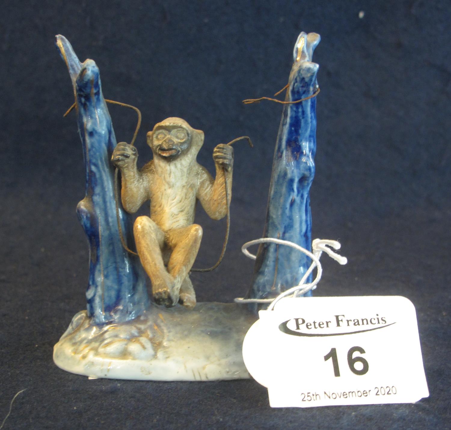 19th Century German porcelain figure of a monkey on a swing, impressed marks to base, 8cm high