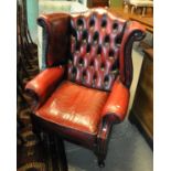 Oxblood leather Chesterfield style button back wing chair. (B.P. 21% + VAT)