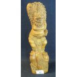A Balinese carved wooden figure of a deity in dancing form with lion mask head dress on naturalistic