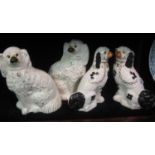 Pair of Staffordshire pottery fireside spaniels with painted features, together with another similar