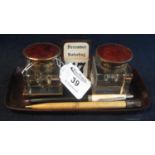 A simulated tortoiseshell brass mounted double inkwell desk stand with central calendar and