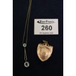 An Art Nouveau aquamarine pendant and a gold plated locket. (B.P. 21% + VAT)