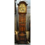 Early 20th Century oak presentation longcase clock in Jacobean style with arched brass face,