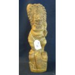 A Balinese carved wooden figure of a deity in dancing form with lion mask head dress on naturalistic