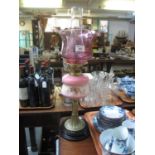 Early 20th Century double oil burner having cranberry glass shade, clear glass chimney above a