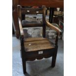 Early 19th century Welsh oak bar back child's chair having shaped open arms and carved shaped apron,