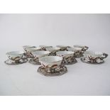 A Vietnamese set of twelve silver mounted porcelain tea cups W9cm and octagonal saucers 11x11cm, the