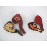 Two antique carved meerschaum pipes in leather boxes. One box with inscription "Fabrique de pipes en