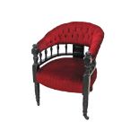 An Arts and Crafts ebonised captains chair, having a spindle gallery back with red velvet buttoned