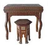 A late 19th/early 20th century Syrian inlaid games table, the rectangular hinged and swivel top