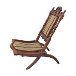 A Victorian carved walnut folding camp chair. W40cm, H83cm.