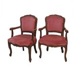 A pair of reproduction carved mahogany open armchairs in the Louis XV style in pink velvet