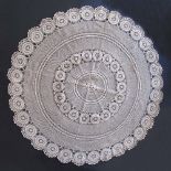 A large beige crochet table cloth of a round shape, diam. 170cm.