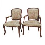 A pair of carved wood Louis XV style armchairs upholstered in tapestry style fabric. Early 20th