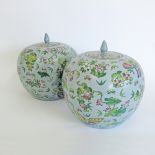 A pair of Chinese spherical shaped porcelain jars and covers. Decorated with sprigs of flowers and