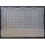 A large beige crochet table cloth of a rectangular shape 180x260cm.