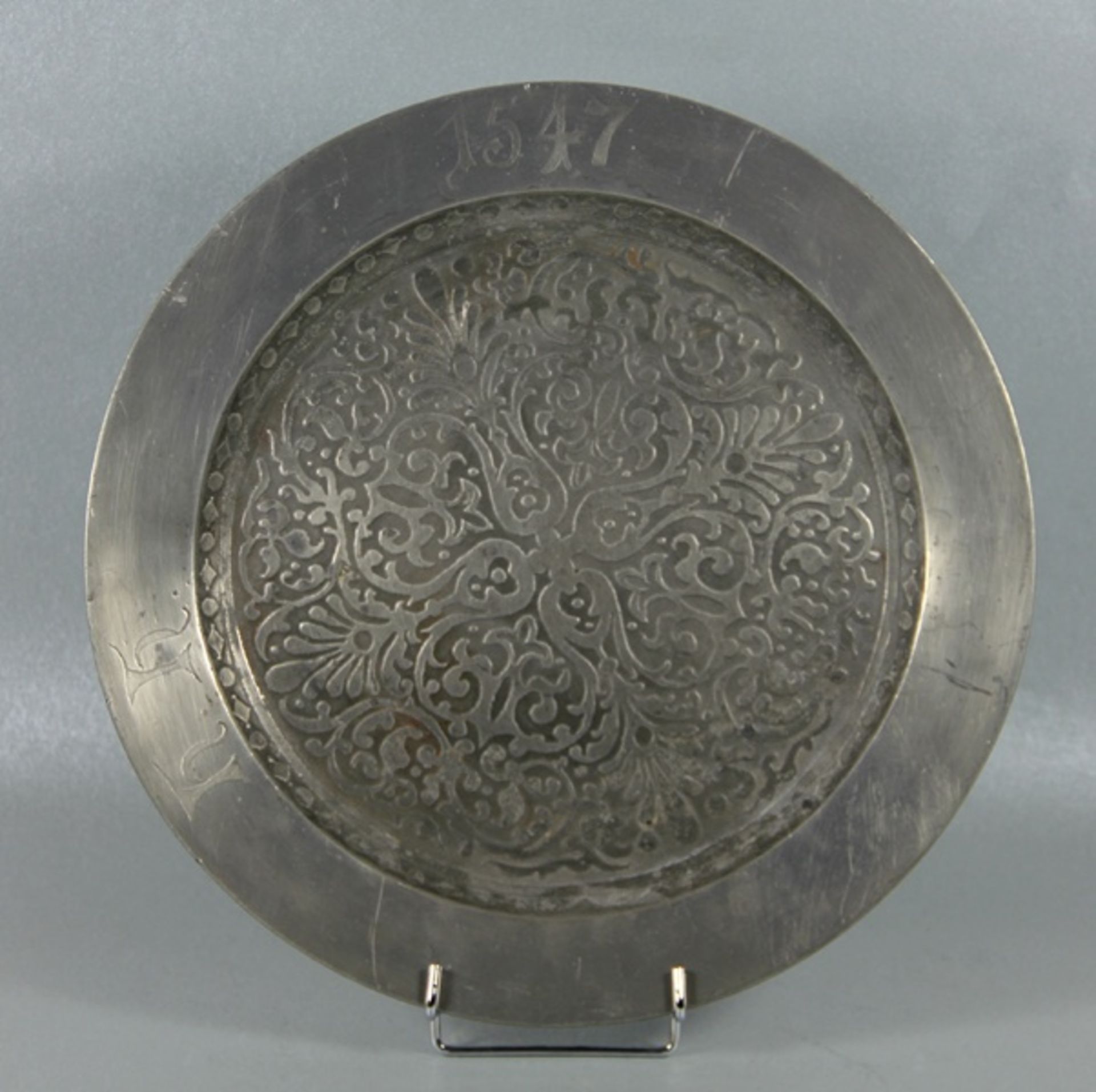 Zinnplattegroße runde Zinnplatte, der Rand graviert h.h. 1547, im Fond reiche Ornamentik, verso