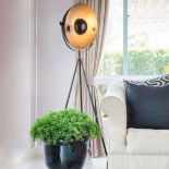 Tripod Floor Lamp A tripod frame made of matt black metal supports a half-open lampshade, which